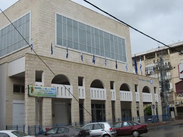 مبنى فرع مؤسسة التأمين الوطني في مدينة عكا، بواجهة حجرية وأقواس في الطابق الأرضي